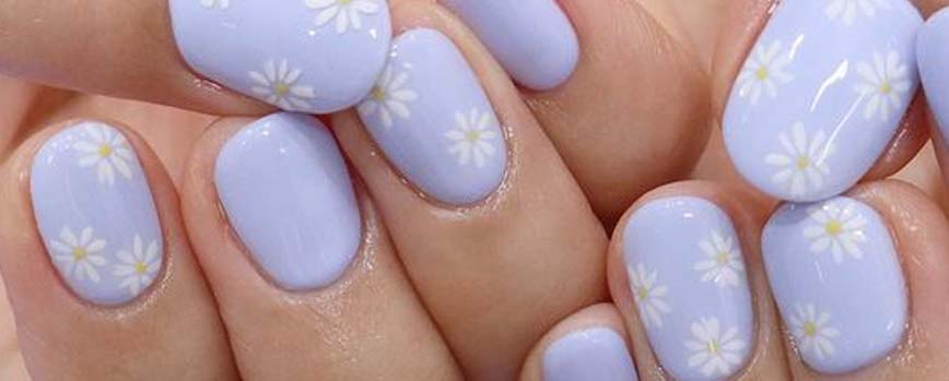 Uñas con margaritas sobre base azul o lila