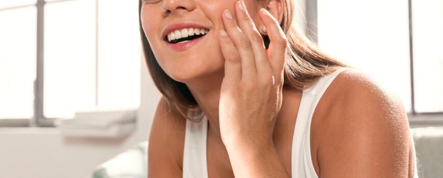Una hermosa mujer joven probando productos de belleza