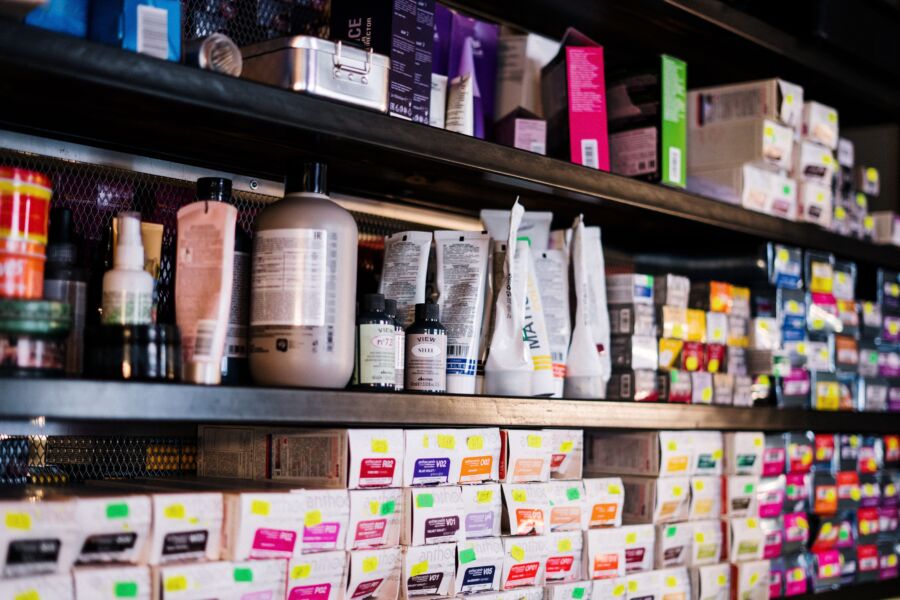 Productos para el cabello profesionales cuidadosamente organizados en los estantes de la peluquería, ideales para los peluqueros.