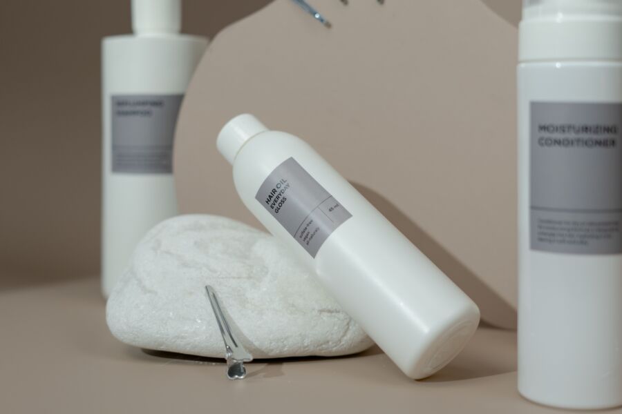 Primer plano de varios productos para el cuidado del cabello exhibidos elegantemente con iluminación suave para uso en spa.