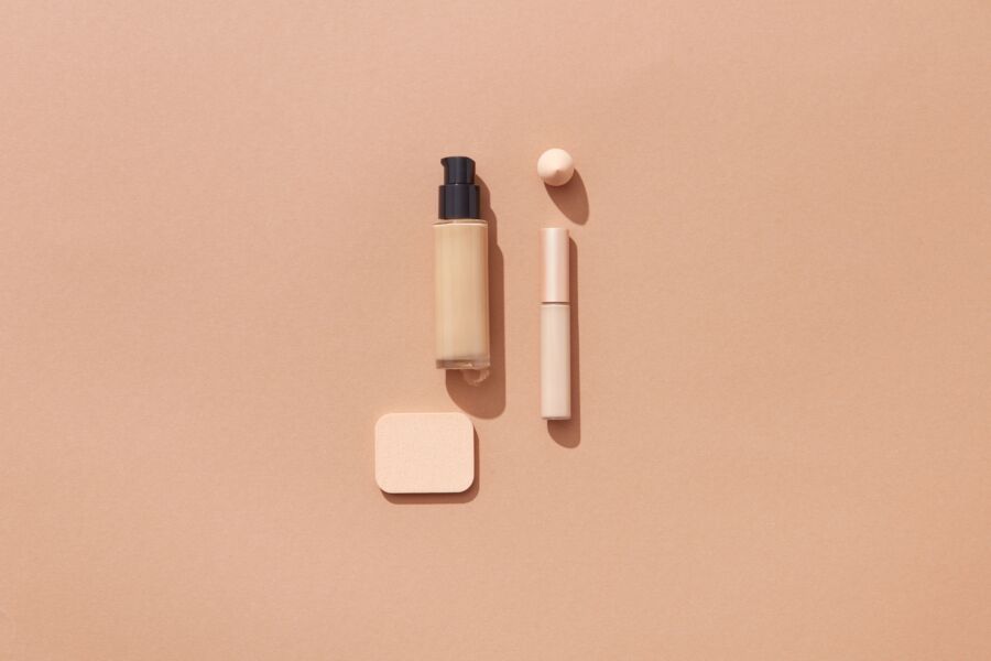 Diseño plano de productos de belleza sobre fondo marrón con espacio para texto, ideal para promociones cosméticas.
