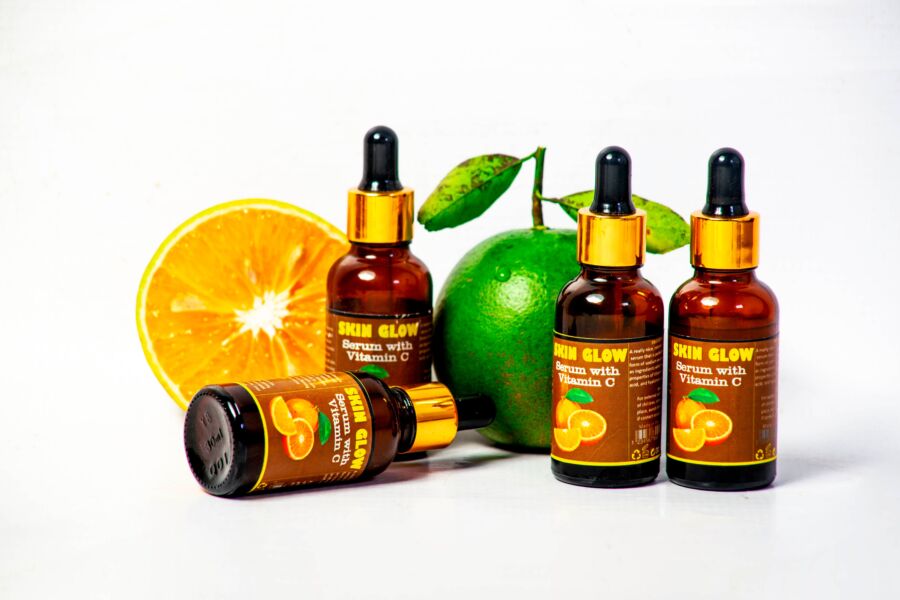 Botellas de suero de vitamina C con cítricos frescos para el cuidado de la piel y la promoción de la salud.
