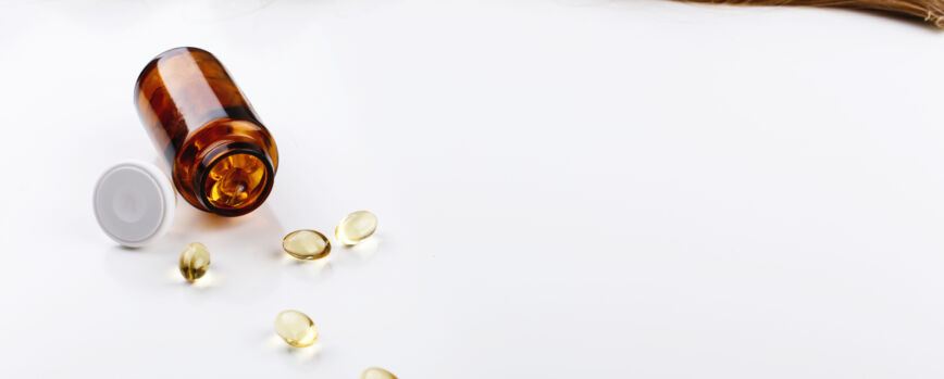 Botella con vitaminas se encuentra antes de curl de cabello castaño