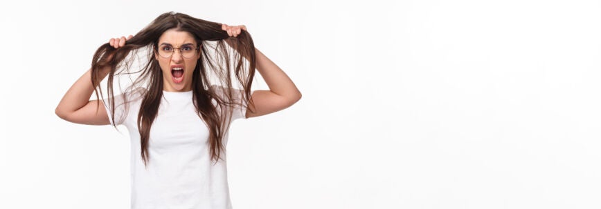 Retrato en la cintura de una joven novia enojada molesta y molesta que pierde los estribos tirando del cabello