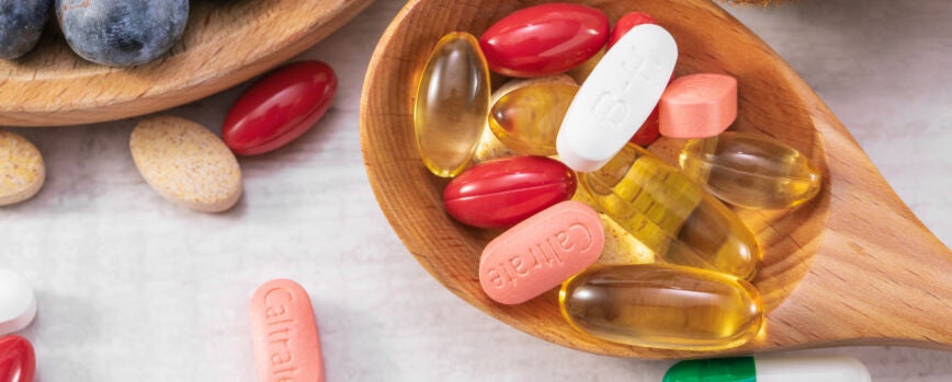 Closeup foto de frutas frescas con diferentes medicamentos en una cuchara de madera