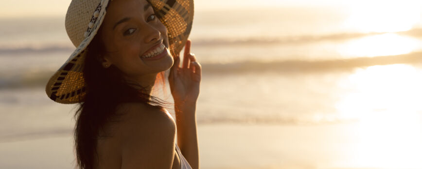 Mujer con sombrero de pie en la playa