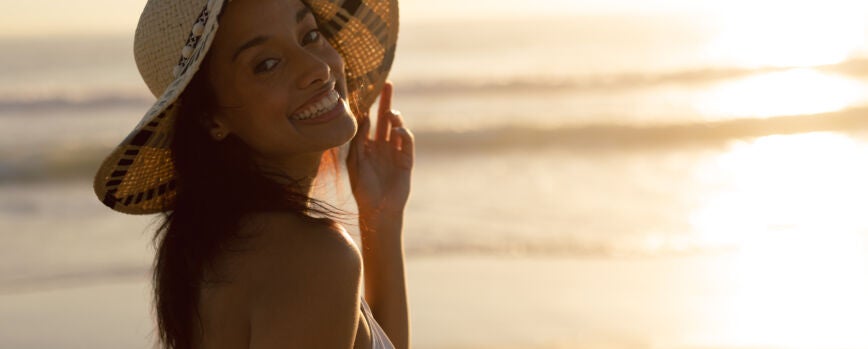 Mujer con sombrero de pie en la playa