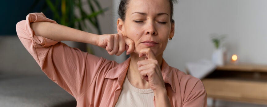 Mujer de tiro medio practicando yoga facial