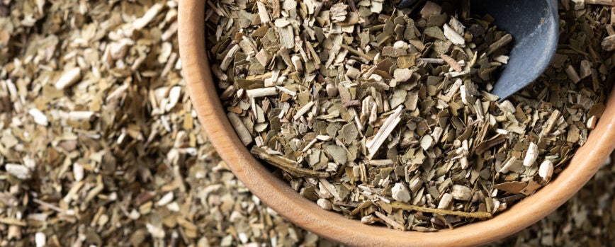 Yerba mate tradicional en un cuenco de madera en una mesa de madera