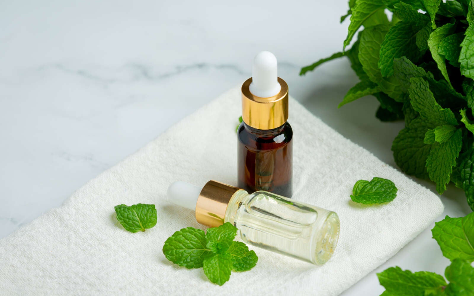 Aceite esencial de menta pimienta en botella con menta verde fresca