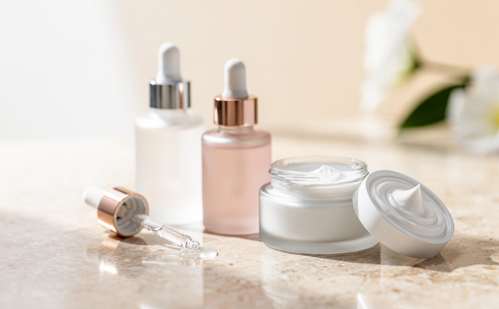 genrame un bodegon de cosmeticos con serums y cremas