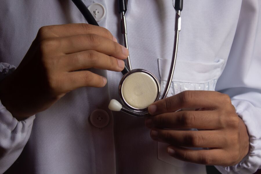 Una imagen en primer plano que muestra a un médico sosteniendo un estetoscopio, que simboliza la atención médica y la práctica médica.