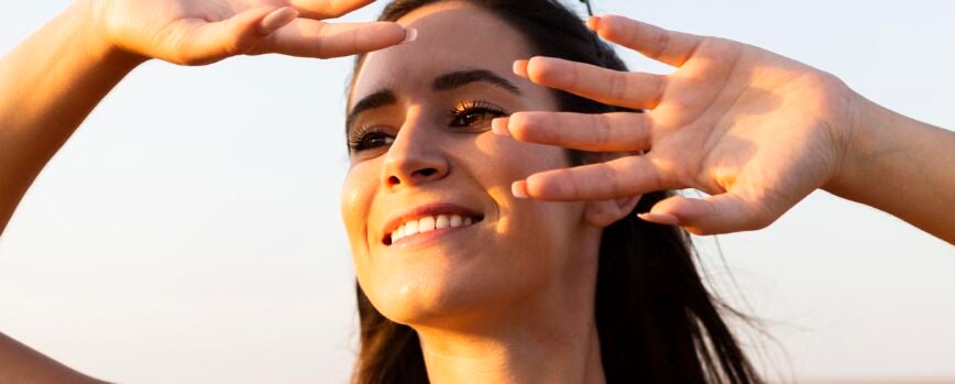 Mujer que cubre su rostro del sol mientras está al aire libre
