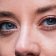 Primer plano detallado de los ojos azules de una mujer, destacando el maquillaje natural y el delineador de ojos.