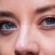 Primer plano detallado de los ojos azules de una mujer, destacando el maquillaje natural y el delineador de ojos.