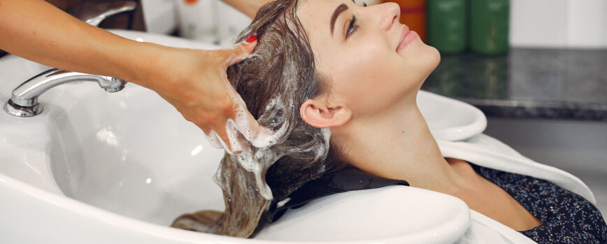 Hombre lavando el cabello de un cliente