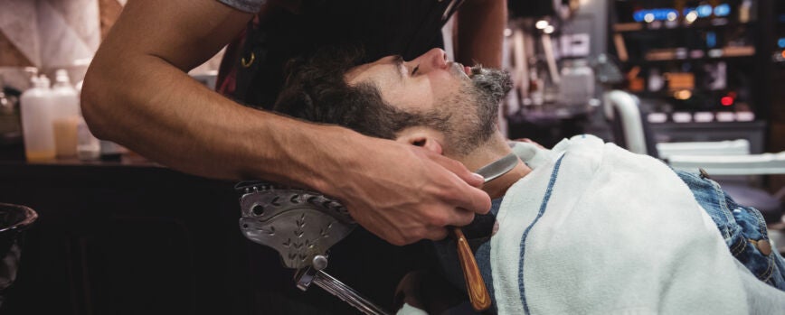 Hombre afeitado la barba con navaja