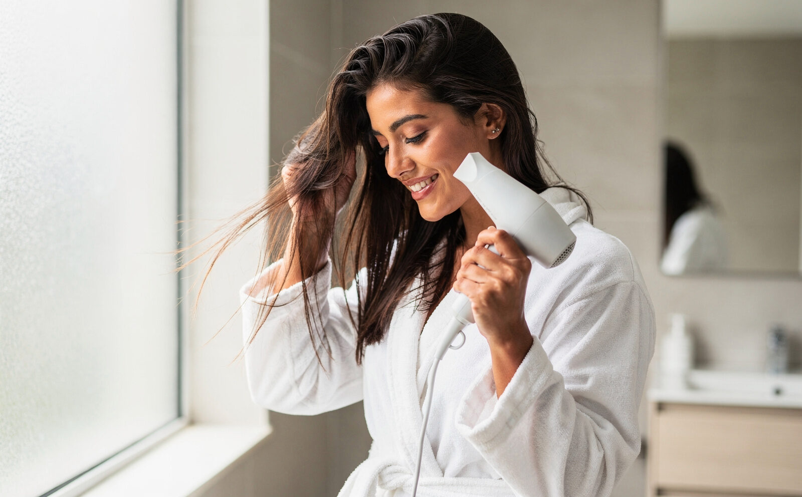 mujer se seca el cabello