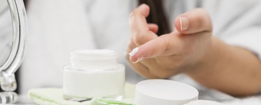 Mano de primer plano con crema en el dedo