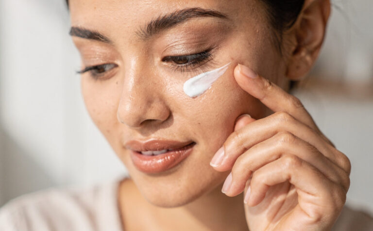 chica se pone crema en el contorno de los ojos