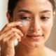 mujer aplicandose crema en el contorno de los ojos