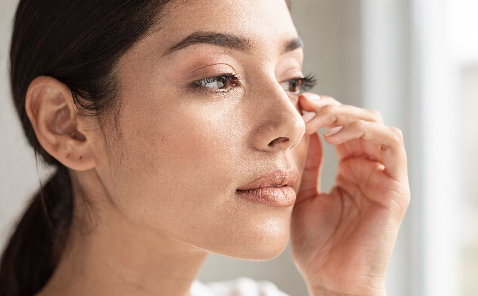 mujer se pone contorno de ojos
