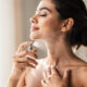mujer se pone perfume en el cuello