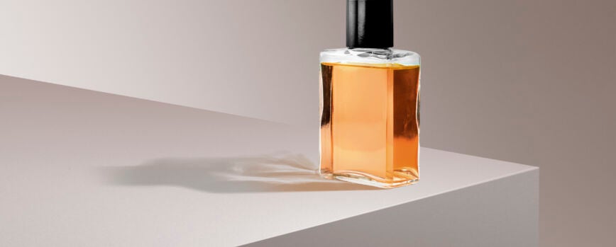 Botella de perfume sobre fondo de producto rosa