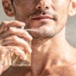 hombre se pone perfume en primer plano, sofisticado