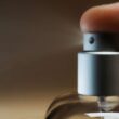 Detallado disparo capturando el dedo presionando una botella de spray de perfume, ilustrando un momento de acción.