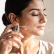 Mujer flitandose perfume sutilmente en primer plano