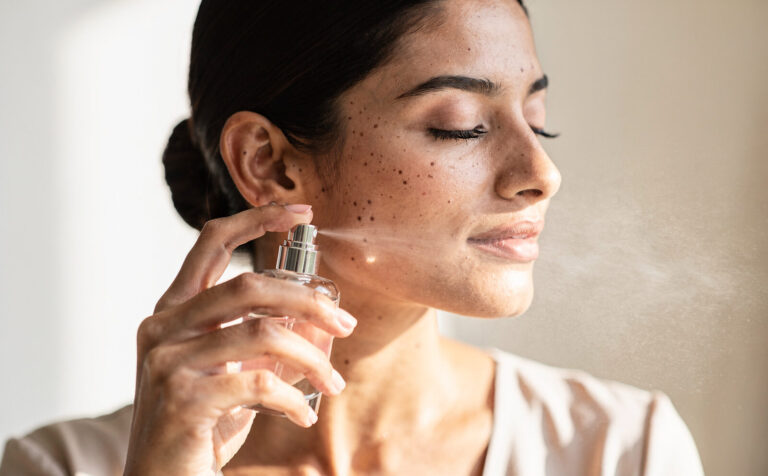 Mujer flitandose perfume sutilmente en primer plano