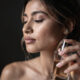 mujer se hecha perfume en un ambiente oscuro