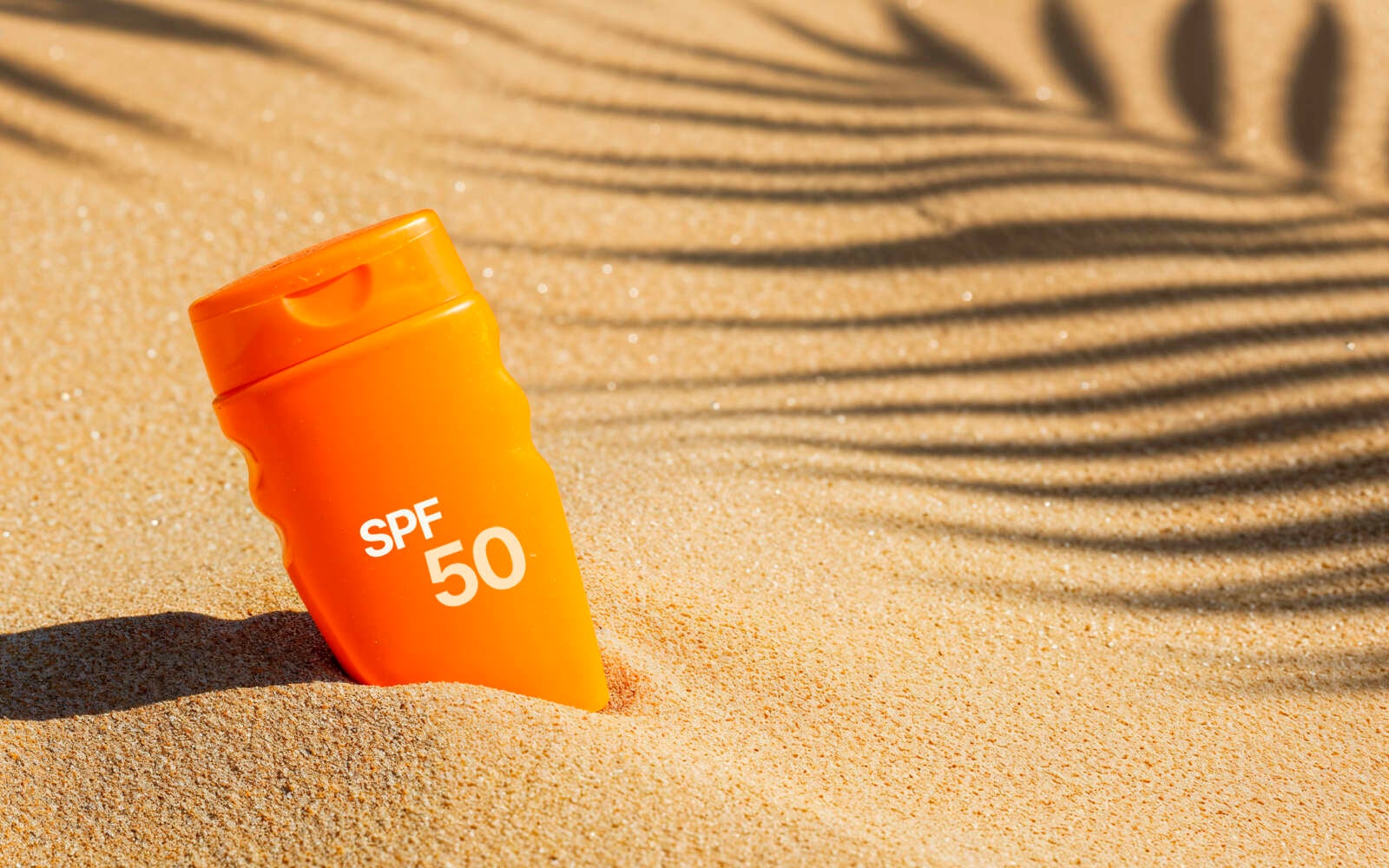 Protector solar SPF 50 en la playa de arena