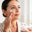 mujer poniendose crema facial antiarrugas