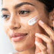 mujer se pone crema facial en la cara primer plano