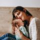 Un momento de amor entre una madre y su bebé, compartiendo un tierno abrazo en el interior.