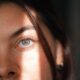 Primer plano íntimo de la cara de una mujer con luz natural suave, enfatizando las características.
