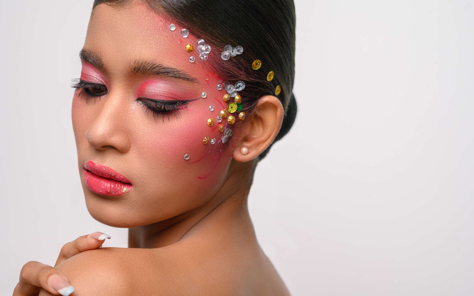 Mujer con maquillaje rosa y adornos en su rostro aislado en blanco