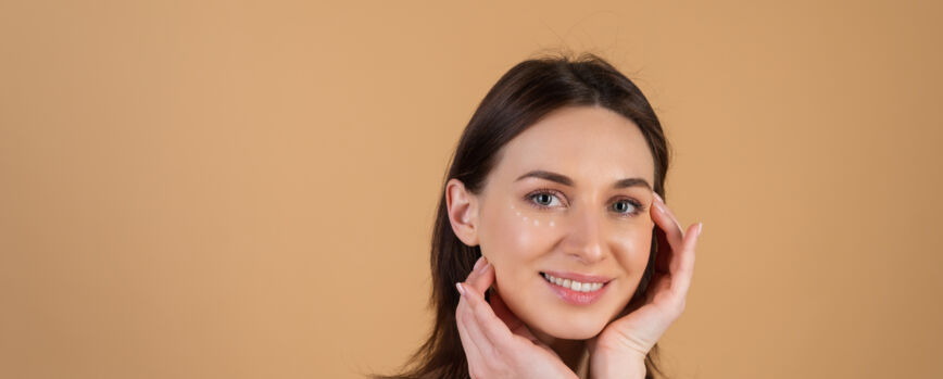 Mujer que aplica la crema en la cara