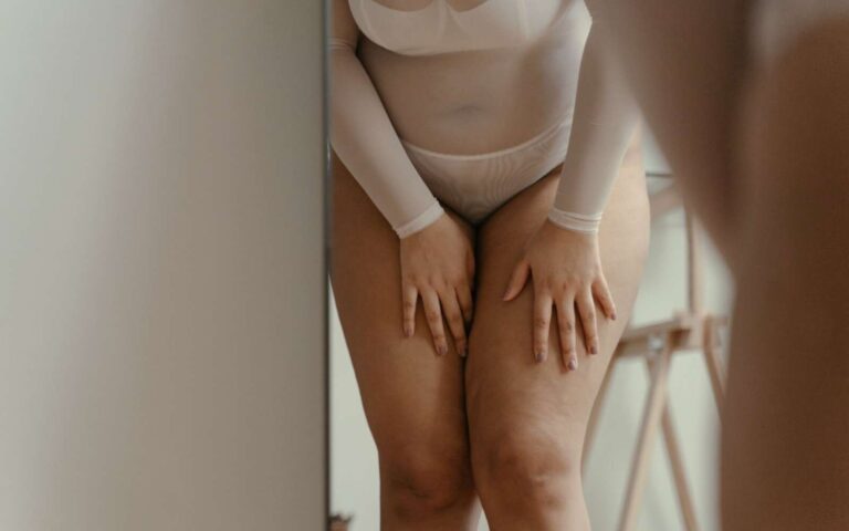 Una mujer segura de sí misma en lencería de tallas grandes posando en interiores, celebrando el amor propio y la positividad corporal.