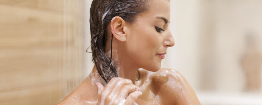 Mujer lavarse el cabello bajo la ducha