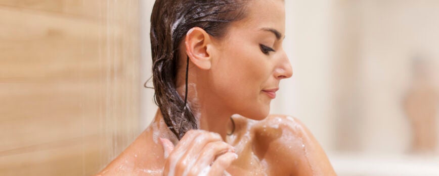 Mujer lavarse el cabello bajo la ducha