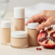 cosmeticos cremas  y al lado una granada fruta
