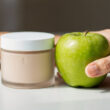 producto cosmético y manzana al lado