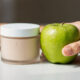 producto cosmético y manzana al lado