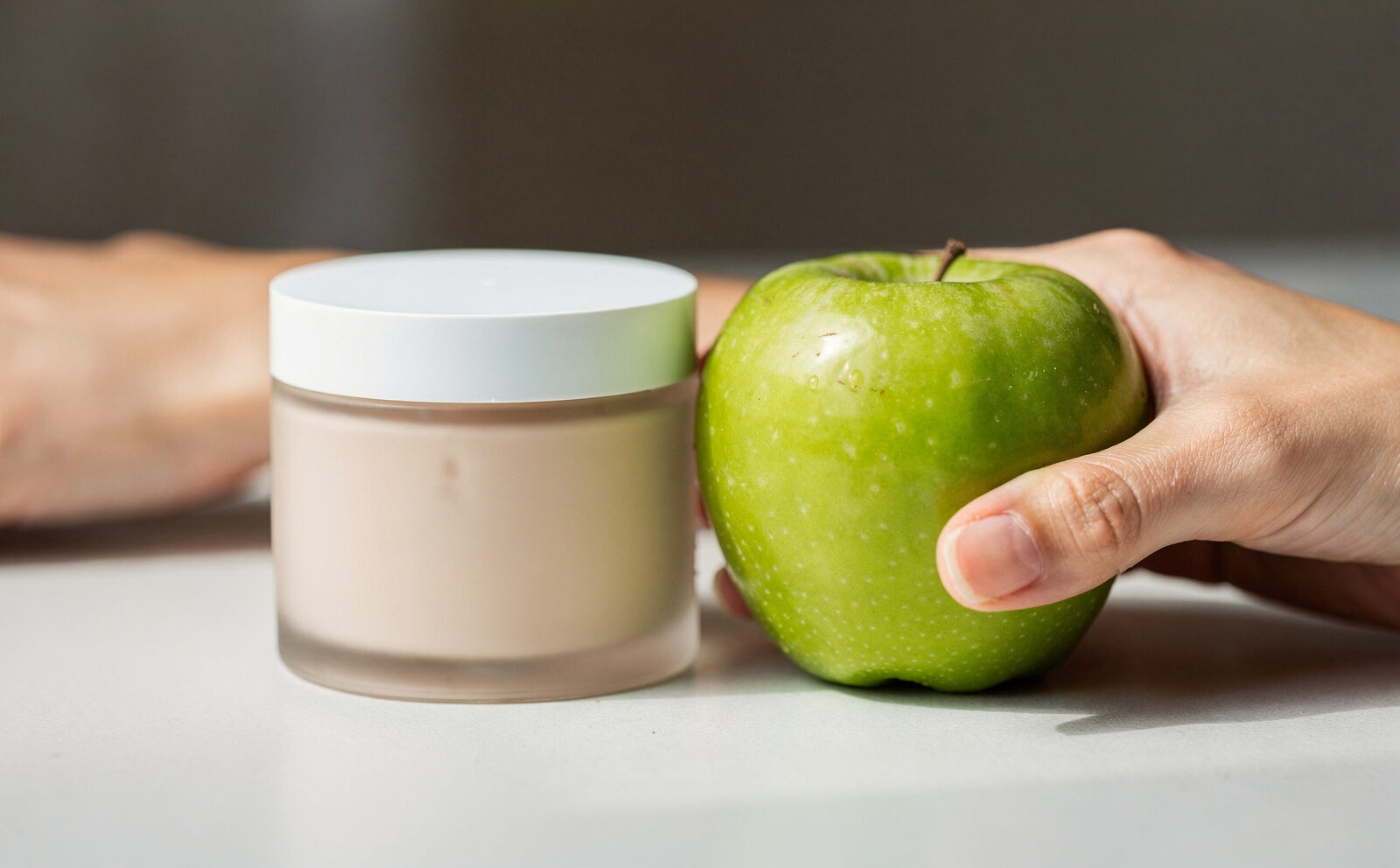 producto cosmético y manzana al lado