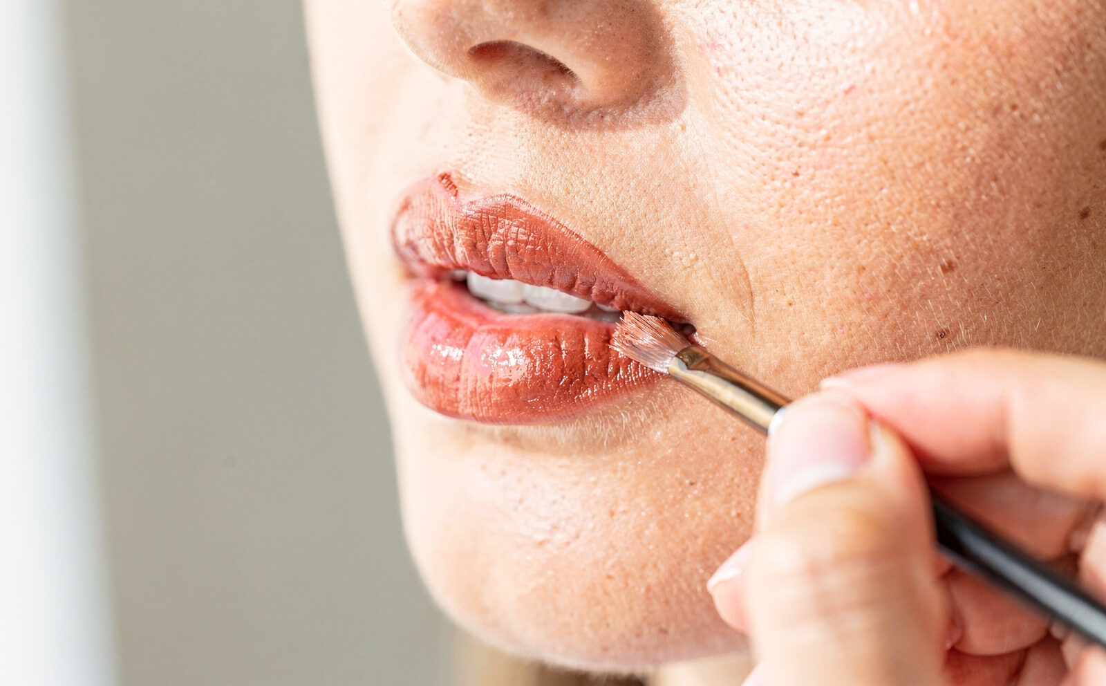 Aplicación de labial con pincel, textura visible, sin foto "antes/después"