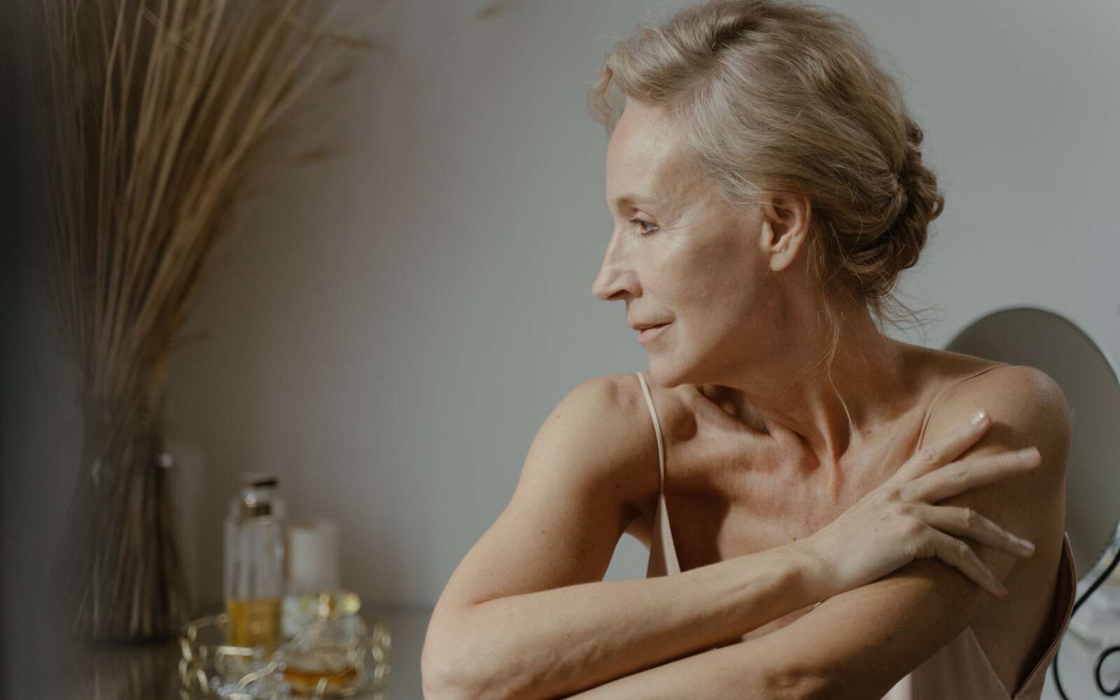 Un retrato sereno y elegante de una mujer madura en una pose relajada en el interior, que muestra la belleza natural.