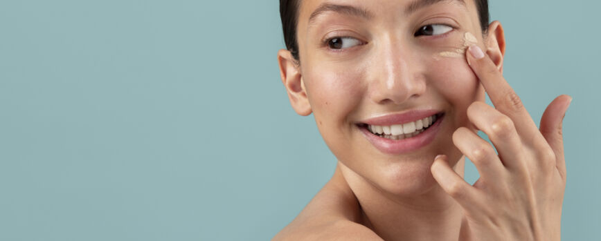 Vista lateral mujer aplicando crema facial